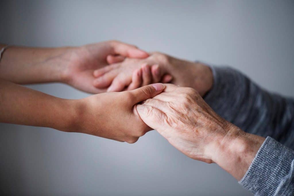 Old and young hands clasped together