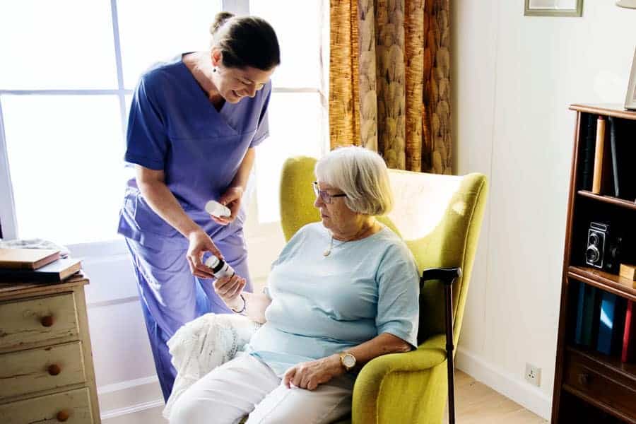 Nurse dispensing medication to homecare patient