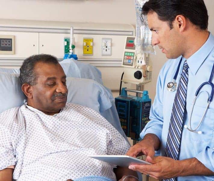 Doctor speaking with male Palliative Care patient in a hospital bed at The Connecticut Hospice