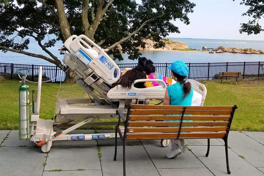 A hospice patient receiving respite care and enjoying water views from his hospital bet at The Connecticut Hospice