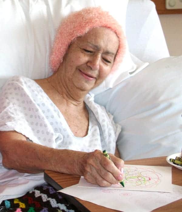 An Elderly Female Hospice patient enjoying the Connecticut Hospive Arts program in her hospital bed