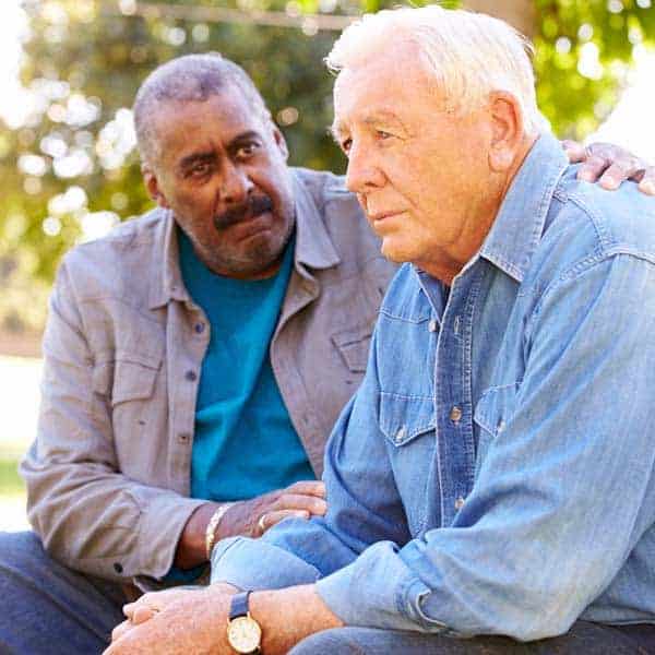 A senior man speaking with a social worker