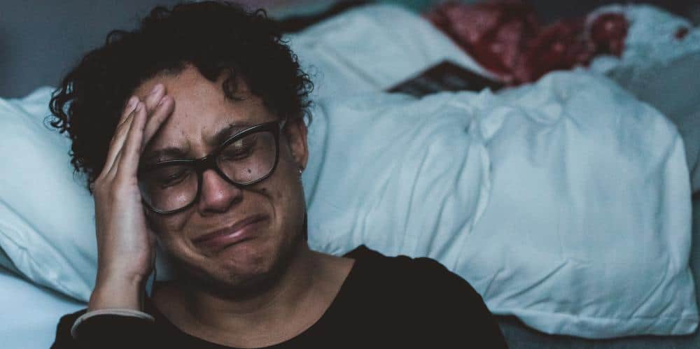 Female caregiver crying and experiencing caregiver burnout.