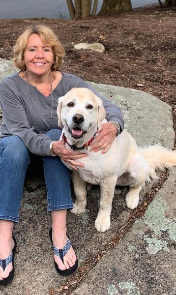 Outdoor picture of pet therapy volunteer holding pet therapy dog