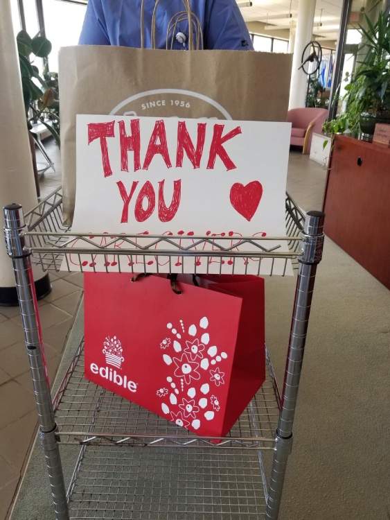 Carrier bags of food donated to Connecticut Hospice, with hand drawn Thank You sign featuring red heart.