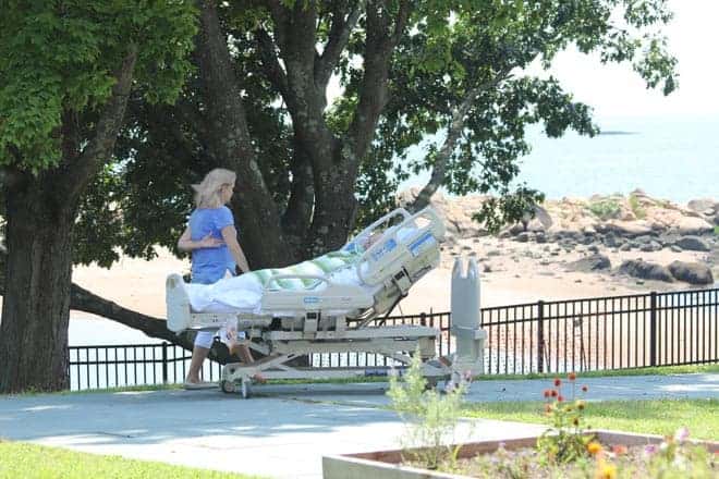 Hospice Patient in hospital bed being wheeled outside to see the water views at Connecticut Hospice in Branford