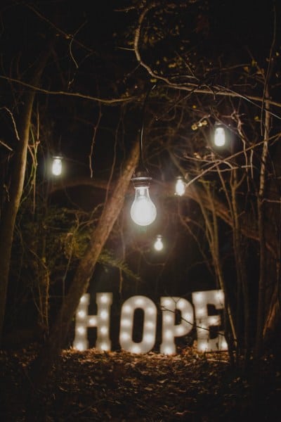 Illuminated letters spelling Hope with light bulbs in dark