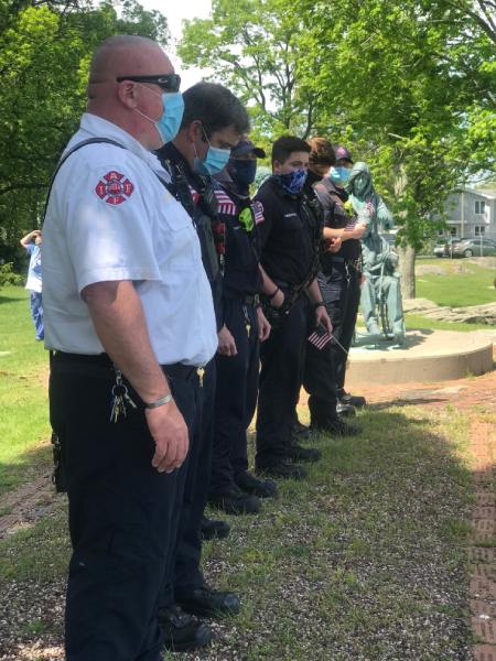 Fire Chief and Firemen in masks stand in line in front of a statue at Connecticut Hospice