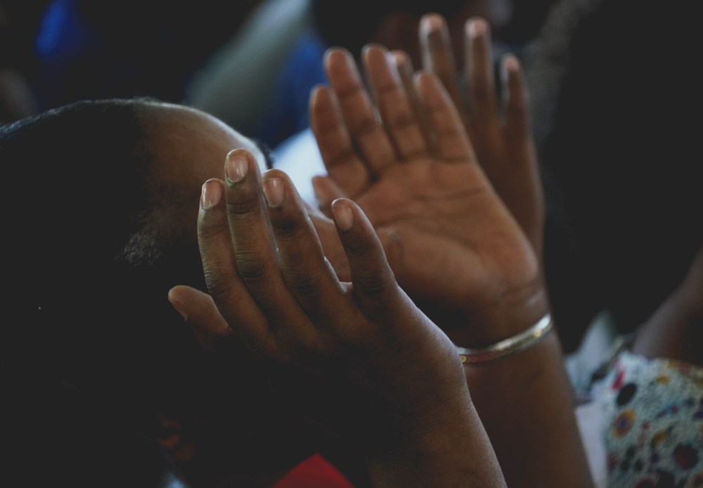 Worshipper's palms upturned on either side of face