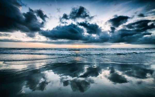 grey clouds over receding tide