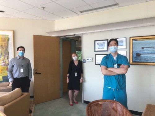 Two doctors face camera with welcoming CEO Barbara Pearce between them