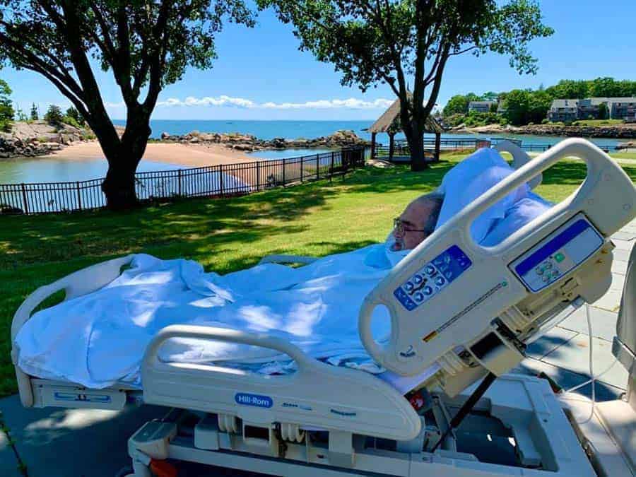 Connecticut Hospice Patient enjoys water views outside from hospital bed.