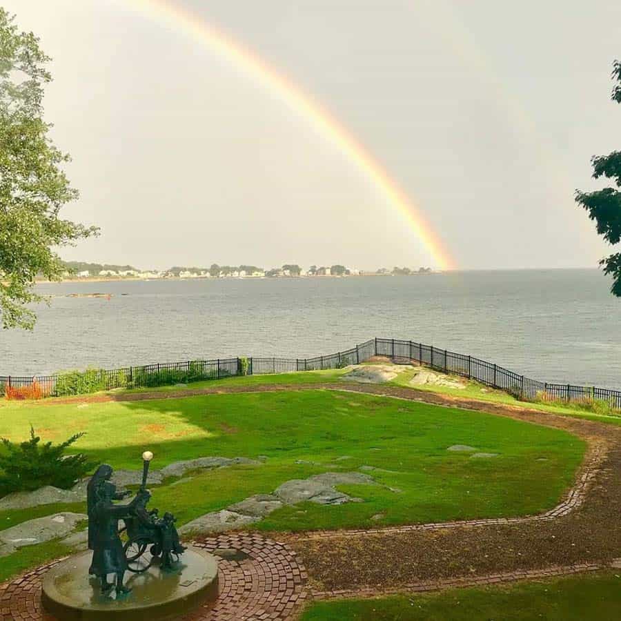 Symbol of Hope sculpture at Connecticut Hospice with rainbow over Long Island Sound in background