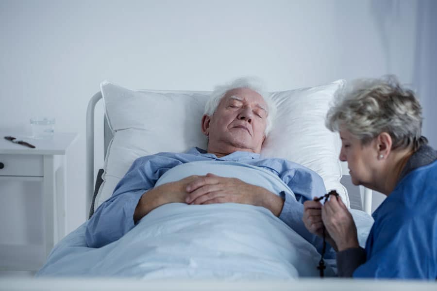 Hospice Patient Sleeping with wife at his bedside
