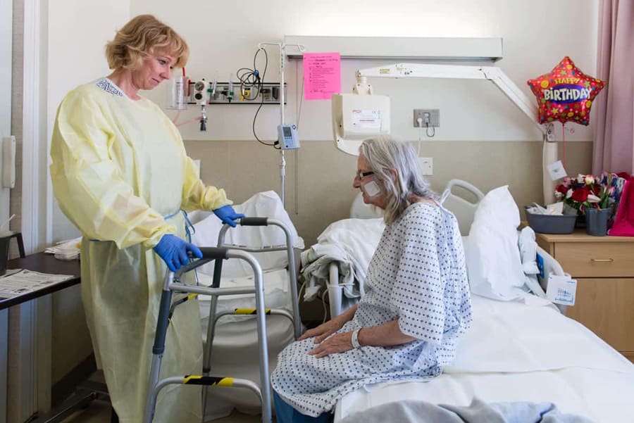 Nurse Hold walker for hospice patient getting out of bed