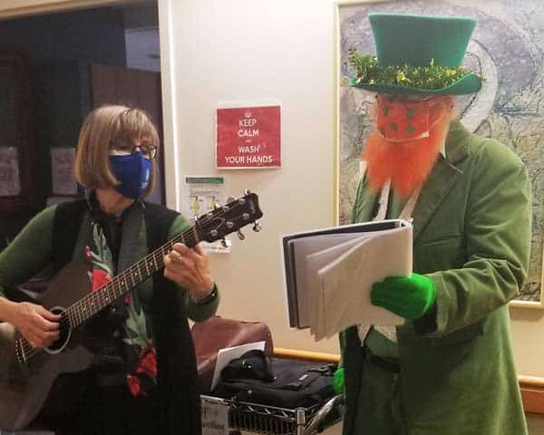 music volunteers sing and play guitar on St. Patrick's Day