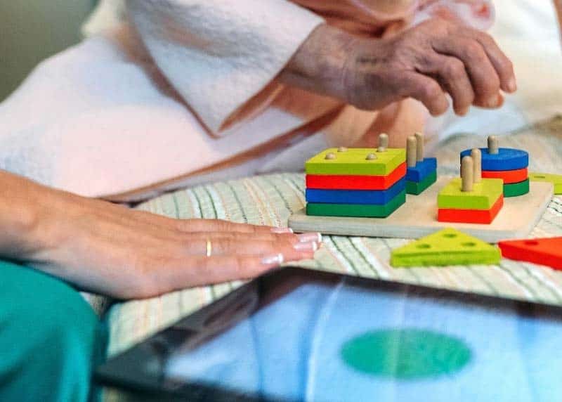 nurse and female patient working on puzzle