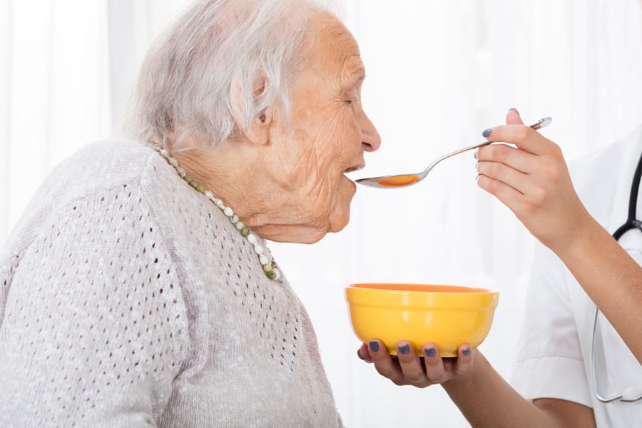 Close-up Of a Hand Feeding Soup To Patient In Hospital
