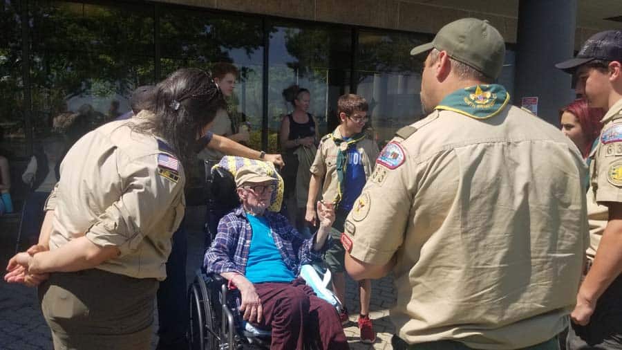 Boy Scouts speaking with veteran in wheelchair