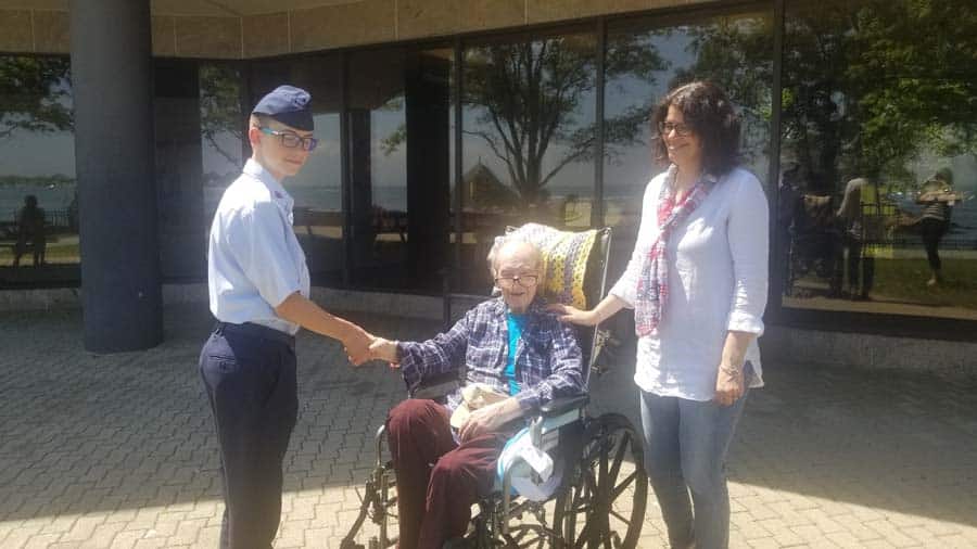 Young military shaking hands with veteran in wheel chair