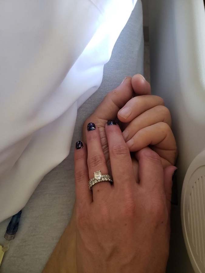 Female hands holding elder hand of patient in bed