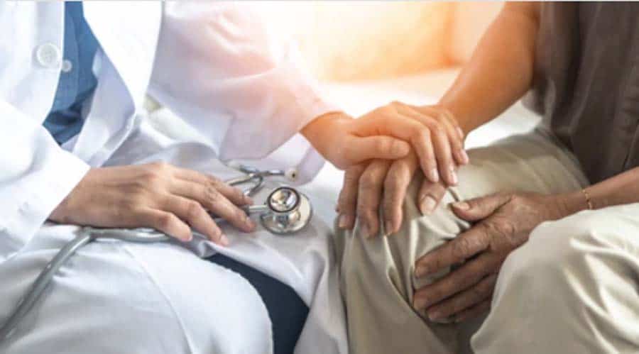 Doctor holding hands of male patient