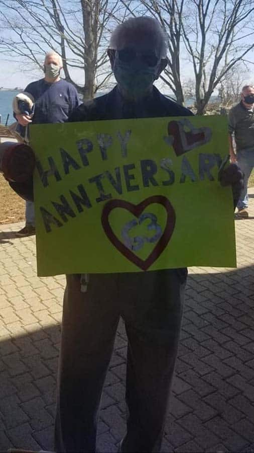 Man holding Happy Anniversary sign