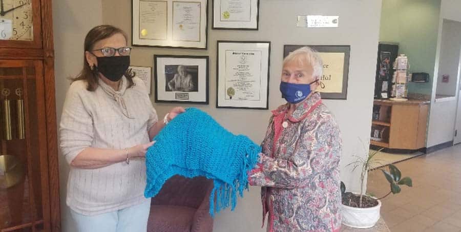 Blue crocheted blanket presented to Hospice