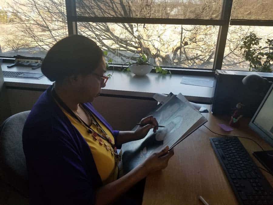 Female artist drawing at desk