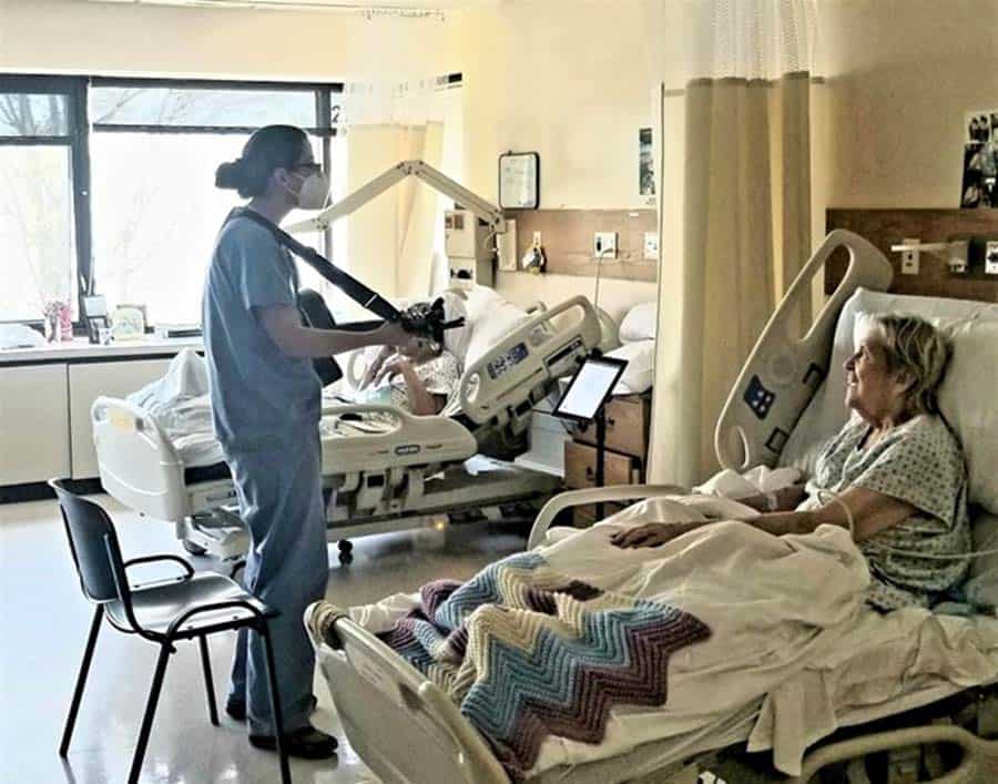 Guitar player with female patient in hospitasl bed