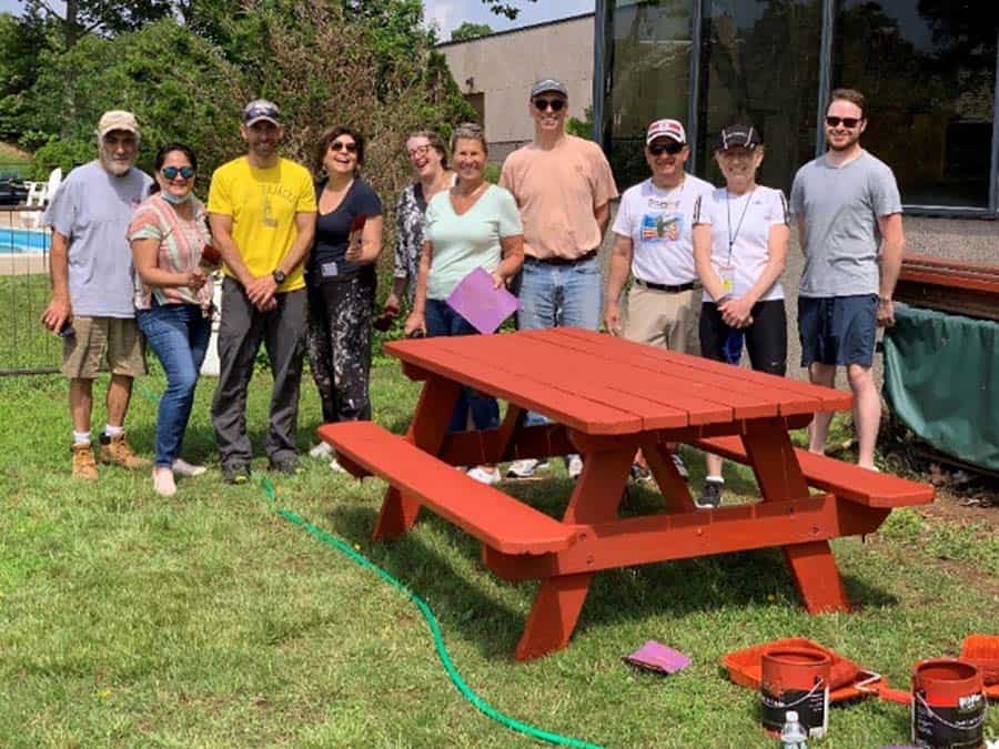 Hospice Volunteers surrounding newly painted picnic table