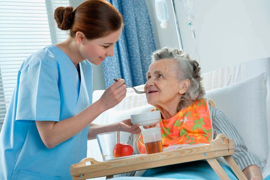 Senior hospice patient being fed by a nurse
