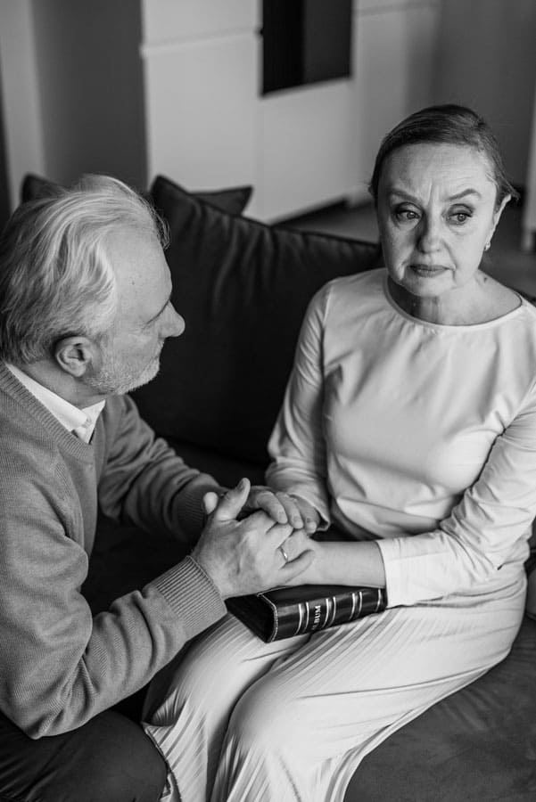 Man comforting emotional female