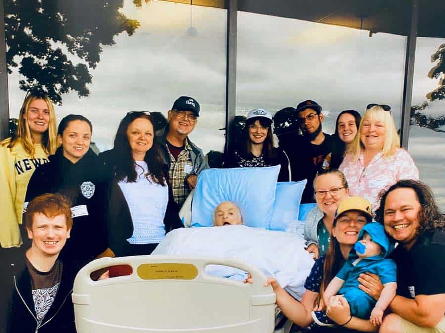 Generations of family outside, surrounding a patient in his bed at Connecticut Hospice