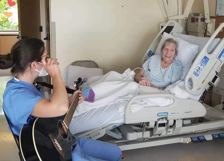 Hospice Staff Member playing the guitar for a patient