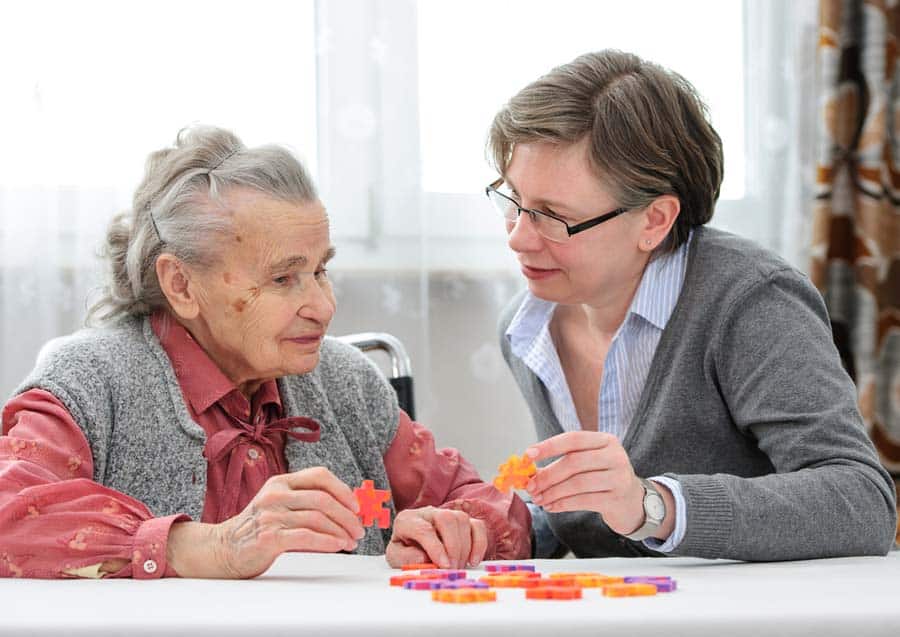 Elderly mother and daughter working a puzzle