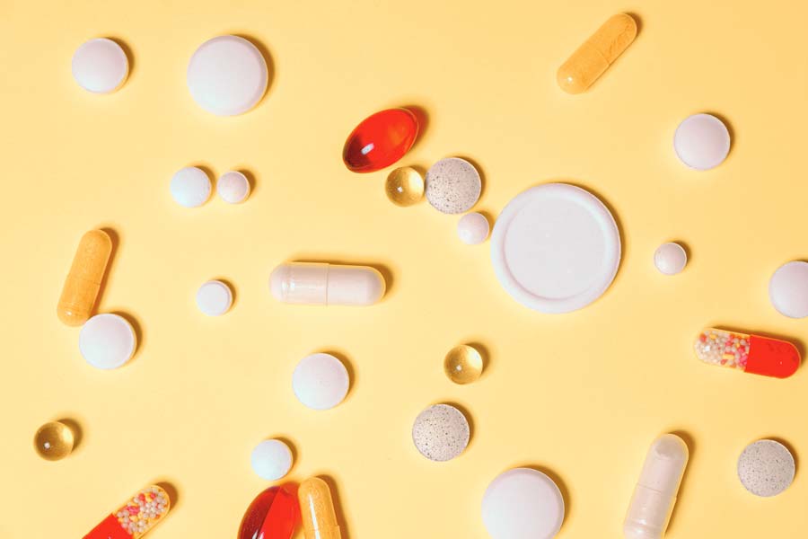 a bunch of different pills on a yellow background