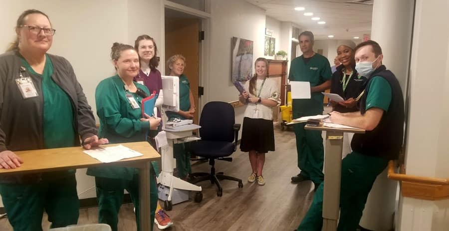 Medical personnel standing in circle on hospital floor