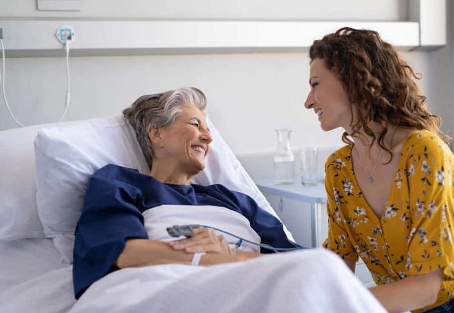 daughter visiting her mother at hospice bedside