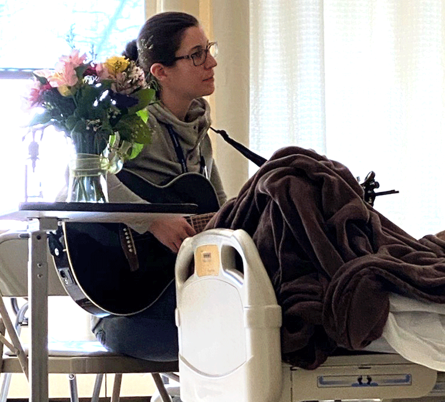 Musician playing guitar at a CT Hopsice patient's bedside