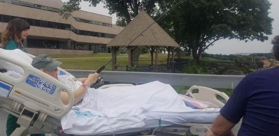 Connecticut Hospice Patient fishing off the deck accompanied by nurses