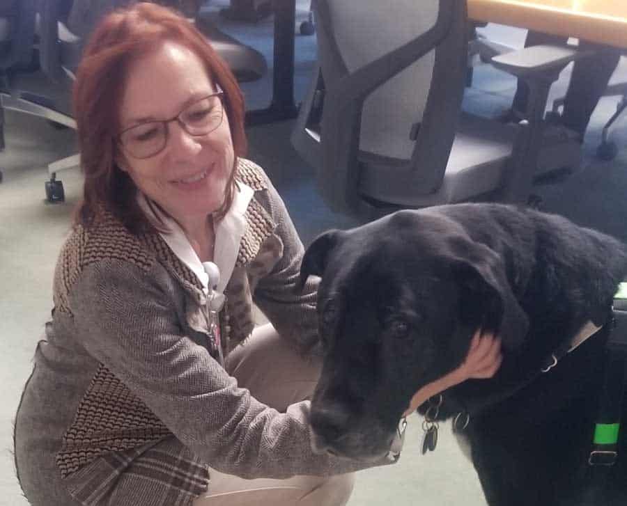 Hospice CEO Sylvia Allais petting a Therapy Dog