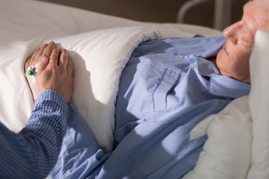 Dementia patient at Hospice with hand being held