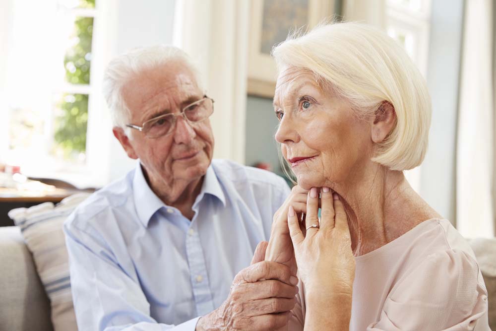 A senior man Comforting Woman With Dementia At Home
